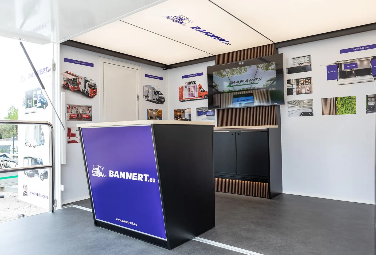 Intérieur d'un camion d'exposition PromoVan : comptoir, écran et parois d'affichage