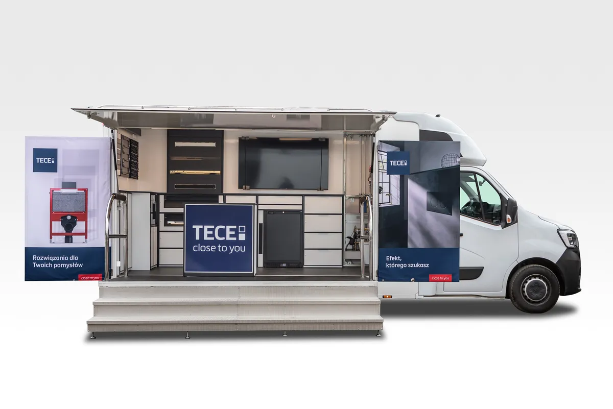 Camion événementiel TECE, trappe relevée, plateforme et escalier déployés devant les vitrines d'exposition