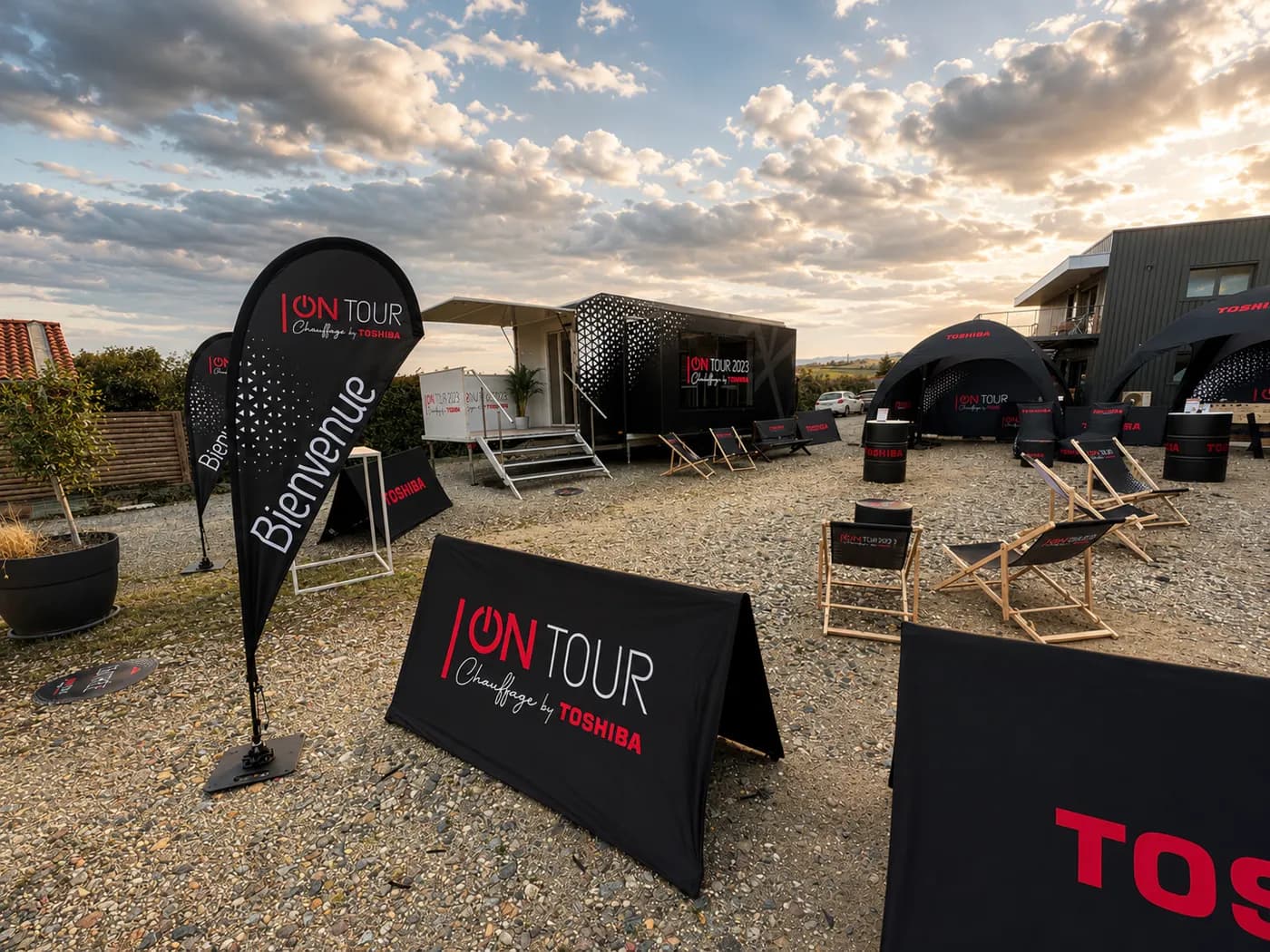 Camp « ON TOUR » : tentes, transats et kakémonos, ciel de fin de journée