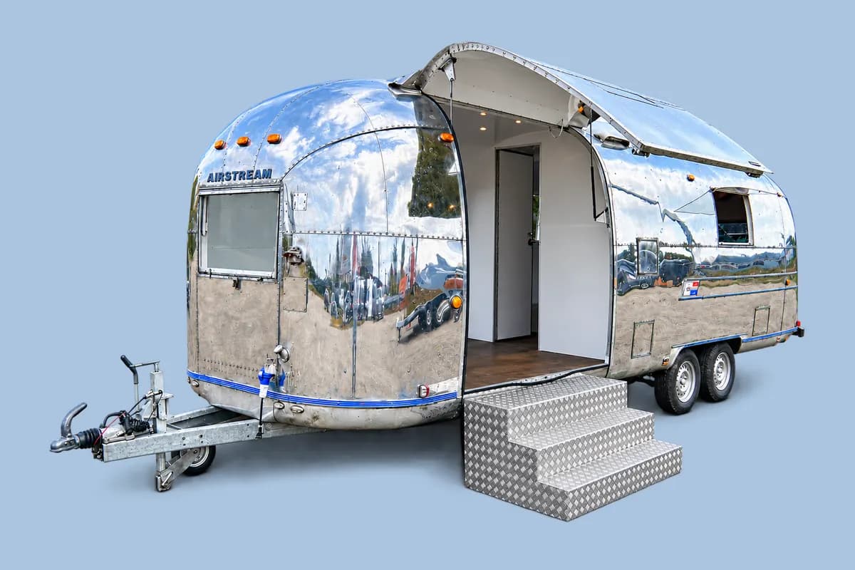 Caravane Airstream Sovereign 1973 chromée, porte ouverte et escalier d'accès