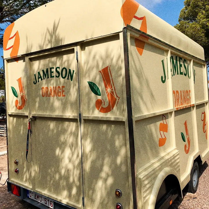 Arrière d'une remorque Citroën HY crème habillée Jameson Orange, stationnée dans une rue